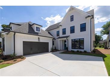 Beautiful two-story home with a dark gray two car garage and a well maintained front yard at 574 Sawnee Village Blvd, Cumming, GA 30040