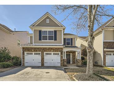 Charming two-story home with a stone-accented facade and two-car garage at 5430 Falls Landing Dr, Cumming, GA 30040
