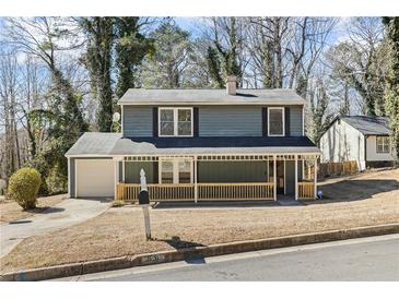 Charming home featuring a covered porch, painted in blue, and a neatly kept front yard at 801 Hemingway Rd, Stone Mountain, GA 30088