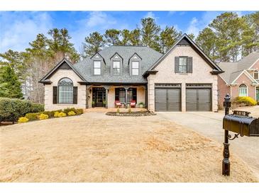Charming brick home with a well-manicured lawn, black shutters, and a two-car garage at 5810 Ripplestone Nw Ct, Acworth, GA 30101