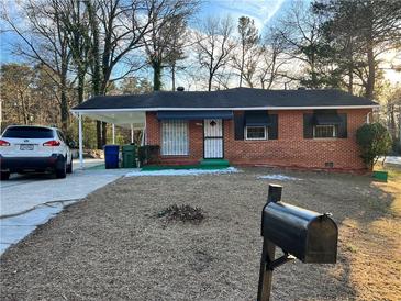 Charming brick home with a carport, tidy landscaping, and a welcoming front yard at 3698 Fairlane Nw Dr, Atlanta, GA 30331