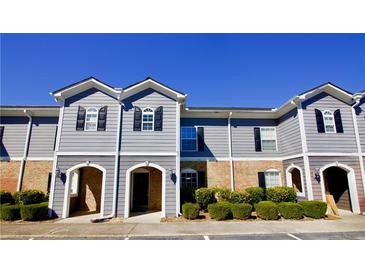 Charming townhouse with gray siding, brick accents, shutters and manicured landscaping at 506 Summer Pl, Norcross, GA 30071