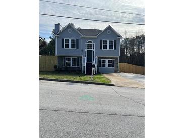 Charming two-story home features gray siding, a well-maintained lawn, and a paved driveway at 7054 Shenandoah Trl, Austell, GA 30168