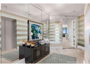 Elegant entryway featuring striped walls, a mirrored wall, dark console table, and artwork at 750 Park Ne Ave # 25W, Atlanta, GA 30326