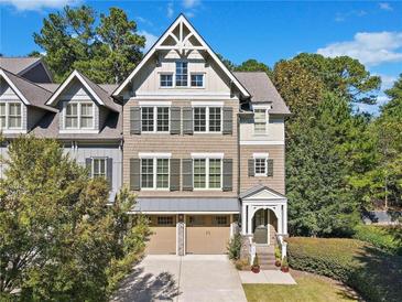 Charming three-story townhouse with attached two-car garage and traditional design on a sunny day at 130 Staddlebridge Ave, Canton, GA 30114