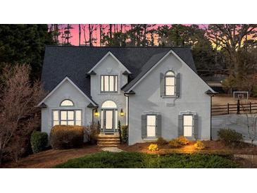 Charming home with elegant gray shutters, manicured lawn, and brick steps leading to an arched entryway at 5382 Whitaker Nw Trl, Acworth, GA 30101