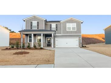 Charming two-story home featuring gray siding, a covered porch, and an attached two-car garage at 5530 Rosehall Pl, Atlanta, GA 30349