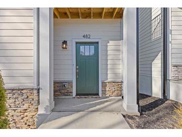 Inviting front entrance with a green door, stone accents, and modern lighting fixture at 482 Hammons Way, Atlanta, GA 30315