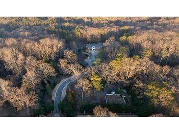 A beautiful home with circular driveway sits nestled amongst lush foliage in a private wooded lot at 4615 Northside Dr, Atlanta, GA 30327