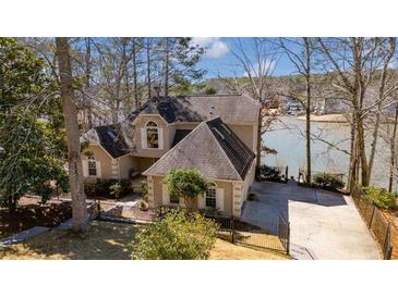 Inviting lake house with a well-manicured lawn, mature trees, and a lake front view at 2333 Sheridan Ct, Villa Rica, GA 30180