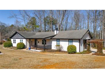 Charming single-story home features a inviting front porch, well-maintained landscaping, and mature trees at 360 Chimney Ct, Fairburn, GA 30213