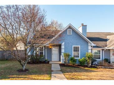 Charming blue home with trimmed landscaping, complemented by a mature tree in the front yard at 4162 Lake Mist Nw Dr, Kennesaw, GA 30144