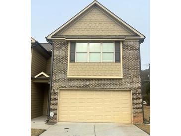 Two-story brick home with a two-car garage and neutral tones at 4421 Fulson Dr, Lilburn, GA 30047