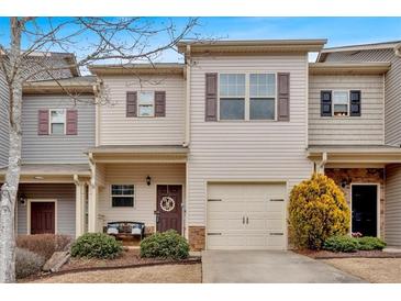 Charming townhome with neutral siding, a one-car garage, and decorative shutters at 553 Oakside Pl, Acworth, GA 30102