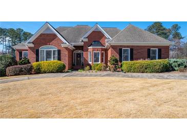 Beautiful, single-story brick home featuring manicured landscaping and a well-maintained lawn at 811 Weeping Willow Dr, Powder Springs, GA 30127