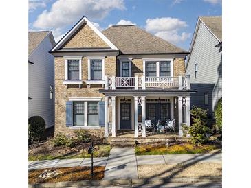 Charming two-story brick home with white trim, inviting front porch, and second-story balcony at 3862 Memphis Dr, Suwanee, GA 30024