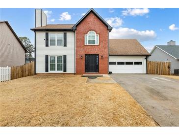 Inviting two-story home featuring a brick facade, white siding, and attached two-car garage at 1445 Wheatfield Dr, Lawrenceville, GA 30043