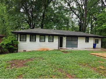 Ranch style home with white painted brick and dark trim, surrounded by mature trees at 3490 Primrose Pl, Decatur, GA 30032