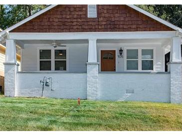 Charming home featuring a covered front porch, white brick foundation, and updated windows at 1575 Montreat Pl, Atlanta, GA 30311