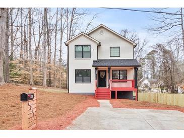 Charming two-story home featuring a red railed front porch and well-manicured front yard at 4041 Blanton Sw Ave, Atlanta, GA 30331