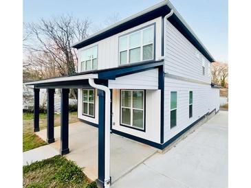 View of the side of the two-story home showing the porch and ample windows at 445 Griffin St, Atlanta, GA 30318