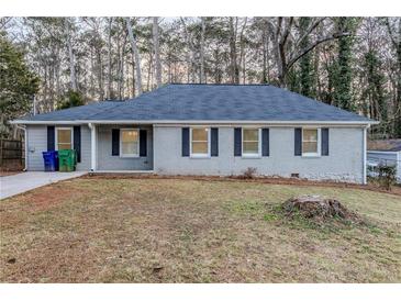 Charming single-story home features gray paint, black shutters, and mature trees at 554 Sherwood Oaks Rd, Stone Mountain, GA 30087