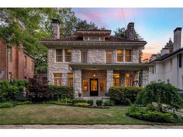Stately stone home with lush landscaping, covered porch, and architectural details, perfect for curb appeal at 121 17Th Ne St, Atlanta, GA 30309