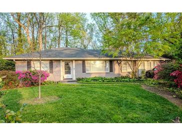 Charming single-story home with lush lawn, beautiful landscaping, and blooming azaleas enhancing its curb appeal at 1263 Briarcliff Ne Rd, Atlanta, GA 30306