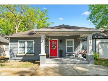 Charming gray bungalow with a welcoming front porch, red door, and well-manicured landscaping at 2599 Church Nw St, Atlanta, GA 30318