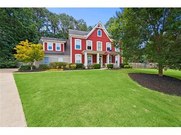 Charming two-story home with a well-manicured lawn, landscaping, and an inviting front porch at 3460 Trow Creek Ln, Cumming, GA 30040