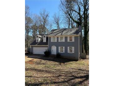 Charming two-story home features a gray exterior, white trim, attached garage, and well-maintained landscaping at 641 Spring Forest Dr, Lawrenceville, GA 30043