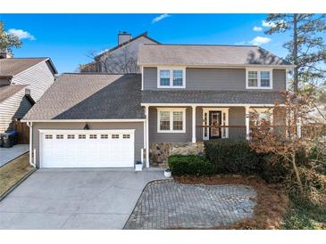 Charming gray two-story home with well-manicured landscaping and a two-car garage at 105 Kinross Ct, Roswell, GA 30076