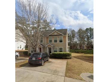 Inviting townhome with neutral siding, well-manicured landscaping, and a private driveway at 637 Outlook Way, Atlanta, GA 30349