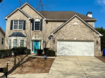 Charming two-story brick home with well-manicured lawn and a bright blue front door at 7597 Cole Ln, Atlanta, GA 30349