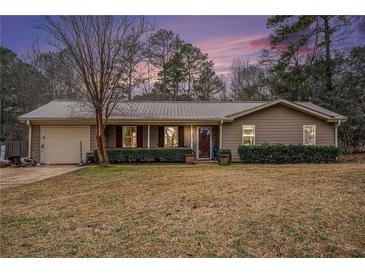 Charming ranch-style home with metal roof and well-manicured lawn, perfect for suburban living at 4775 Hemlock Se Dr, Conyers, GA 30094