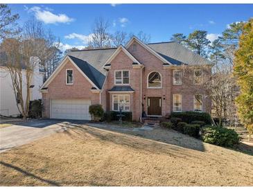 Charming brick two-story home with well-manicured landscaping and an attached two-car garage at 735 Amberton Close, Suwanee, GA 30024