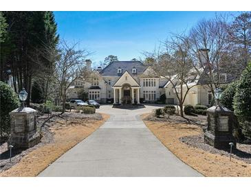 Stately home with a manicured front yard, circular driveway, and elegant entrance with impressive columns at 510 Covington Cv, Alpharetta, GA 30022