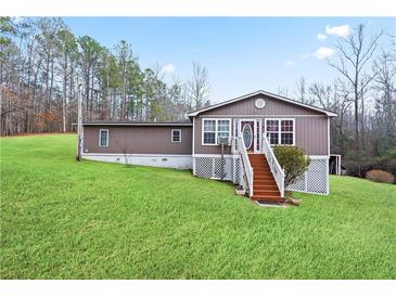 Charming home with a well-maintained lawn and classic exterior, surrounded by mature trees at 209 Sweetwater Trl, Villa Rica, GA 30180