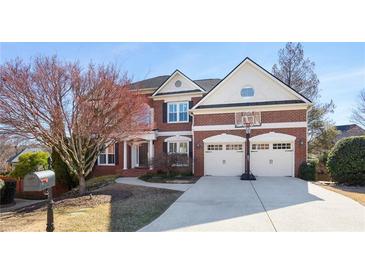Charming two-story red brick home boasts a well-manicured lawn and a two-car garage with basketball hoop at 4095 Oberon Se Ct, Smyrna, GA 30080