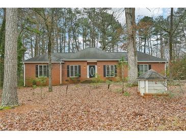 Charming brick home with a symmetrical design and mature trees in a wooded residential neighborhood at 105 Spring Forest Way, Sharpsburg, GA 30277