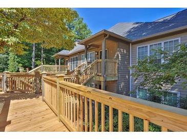 Spacious home featuring an expansive wooden deck and a serene wooded backdrop at 305 Mill Pond Se Ct, Smyrna, GA 30082