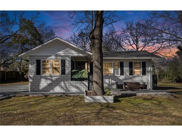 Charming home featuring a brick facade, black shutters, and a cozy front porch sitting area at 850 Third St, Stone Mountain, GA 30083