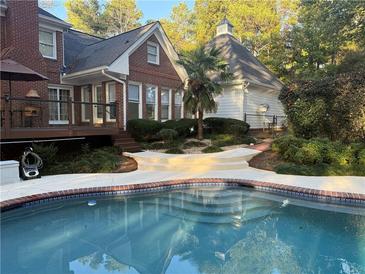 Inviting backyard pool area with landscaped surroundings and stylish deck features for outdoor relaxation at 3320 Donegal Way, Snellville, GA 30039