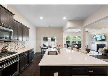 Modern kitchen boasts a large island, stainless steel appliances, and open floor plan to the living area at 2289 Emerald Sky Dr, Smyrna, GA 30080