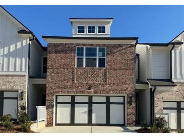 Charming brick townhome with a two-car garage and white trim details at 258 Depot Landing Rd # 53, Auburn, GA 30011