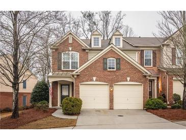 Charming brick townhome featuring a two-car garage, manicured landscaping, and welcoming front porch at 5751 Evadale Trce # 4, Mableton, GA 30126