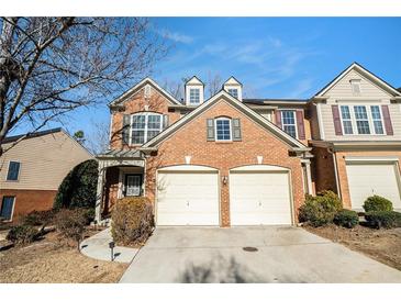 Charming brick townhome featuring a two-car garage and well-maintained landscaping at 5751 Evadale Trace, Mableton, GA 30126