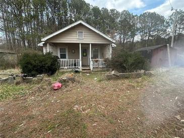 Charming single-story home with a welcoming front porch, set amidst a natural landscape and mature trees at 87 Brushy Path, Rockmart, GA 30153