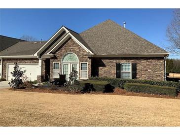 Charming stone-clad house with manicured lawn and inviting outdoor patio area at 3311 Lindenridge Dr, Buford, GA 30519