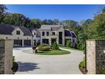 A beautiful two-story home with an inviting circular driveway and elegant landscaping at 700 N Island Dr, Atlanta, GA 30327